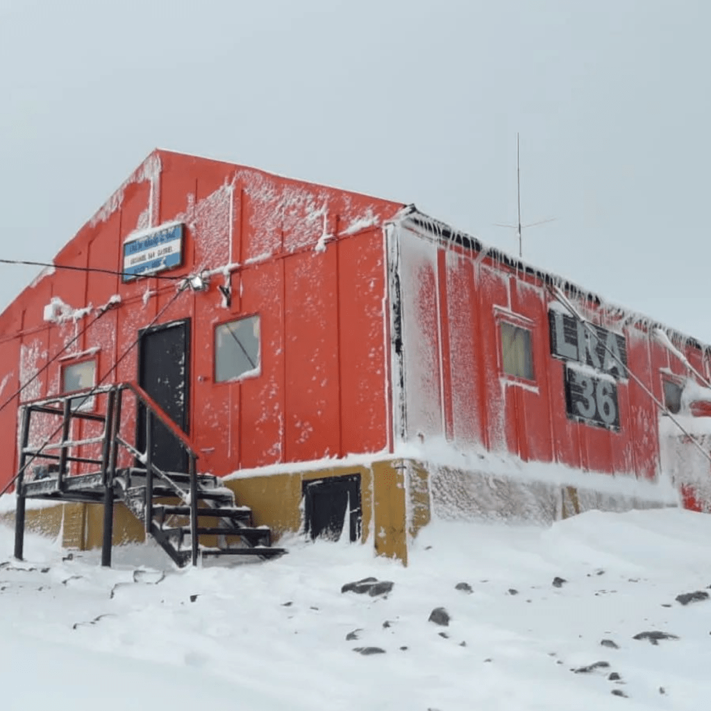 alt= Le Gist_ Photo tagging red-orange house antartica_Argentina radio station