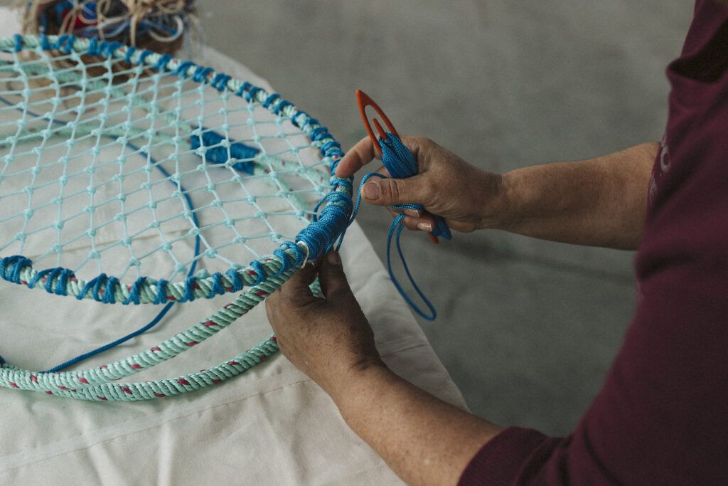 alt= Amallia Puga_weaving fishing nets_ Le Gist Magazine 2024